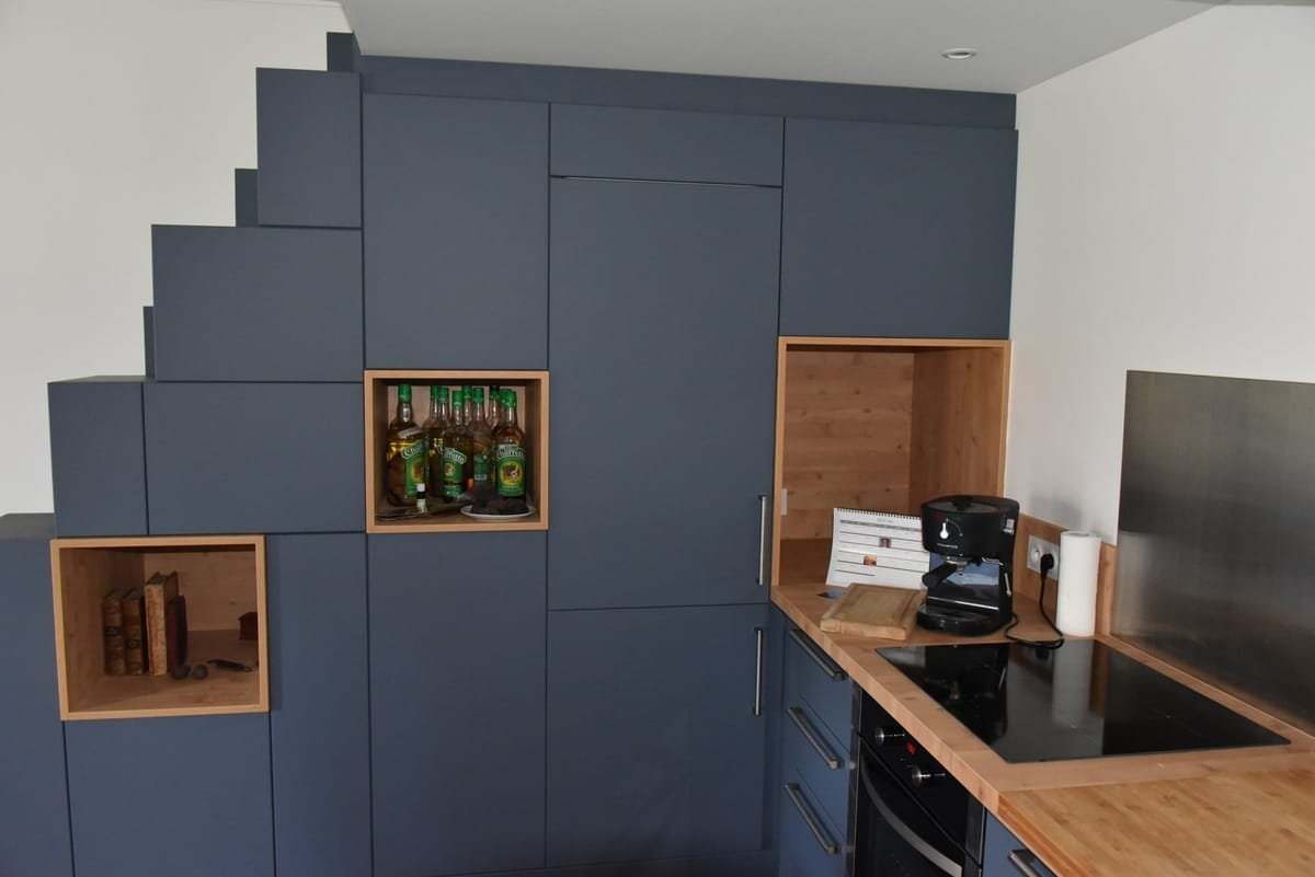 Cuisine sur mesure bleue avec rangements toute hauteur et niches en bois