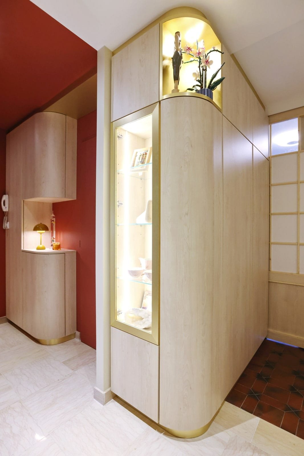 Vitrine éclairée sur mesure en bois clair et laiton pour un espace professionnel